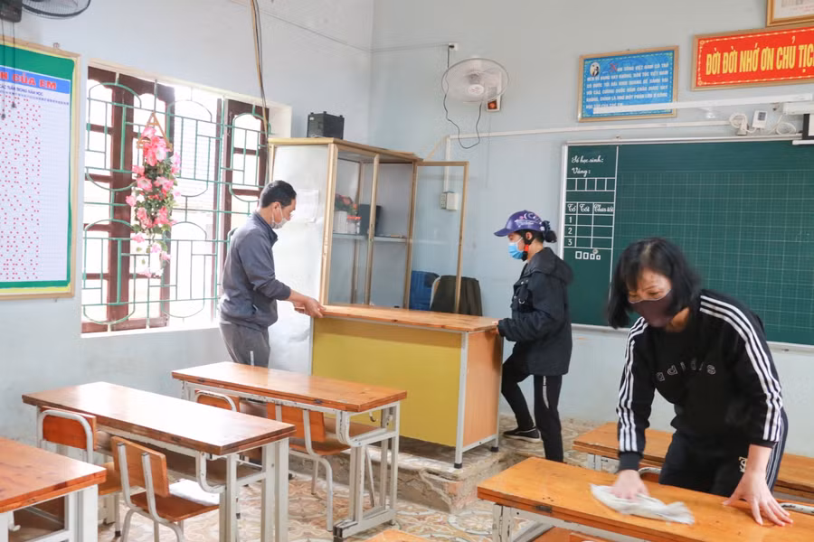 Ngoài giáo viên, nhân viên nhà trường, phụ huynh cũng đến trường phụ giúp lau dọn, sắp xếp bàn ghế cho lớp học của con em mình.