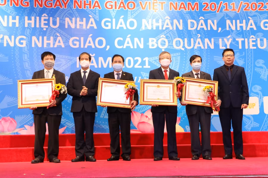 Bộ trưởng Nguyễn Kim Sơn (thứ hai từ trái qua), ông Nguyễn Ngọc Ân (ngoài cùng bên phải) trao danh hiệu Nhà giáo Nhân dân