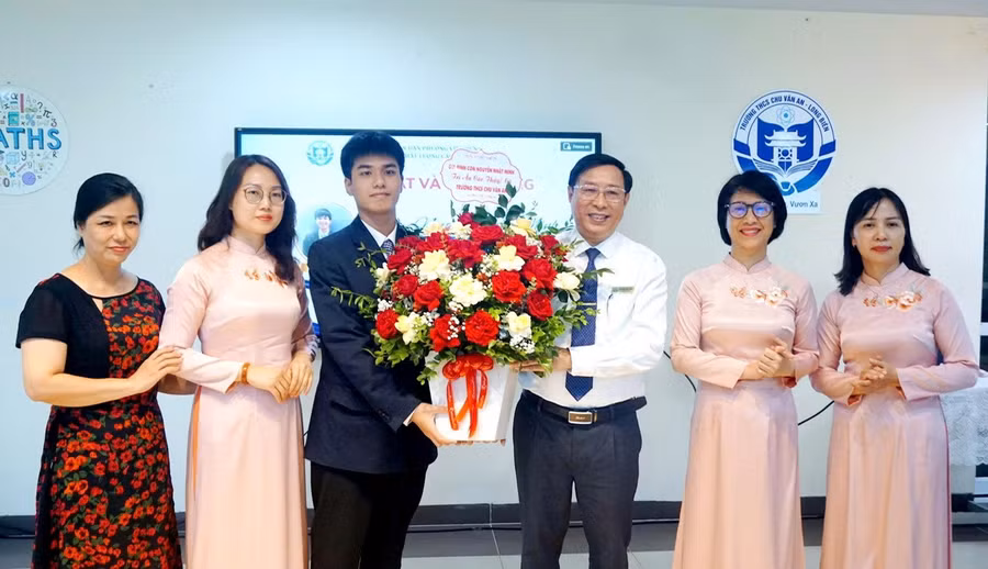 Thầy Tuấn nhận hoa tri ân từ em Nguyễn Nhật Minh, lớp 11 chuyên Lý, Trường THPT chuyên Khoa học Tự nhiên, Đại học Quốc gia Hà Nội giành Huy chương Vàng tại Olympic Vật lý quốc tế 2026. Ảnh NTCC.
