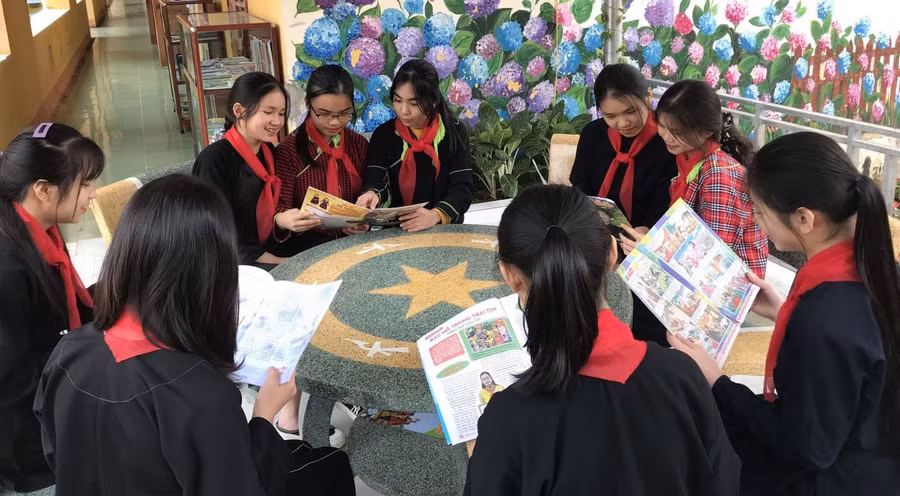 Học sinh đọc sách tại khuôn viên thư viện ngoài trời. Ảnh NT.