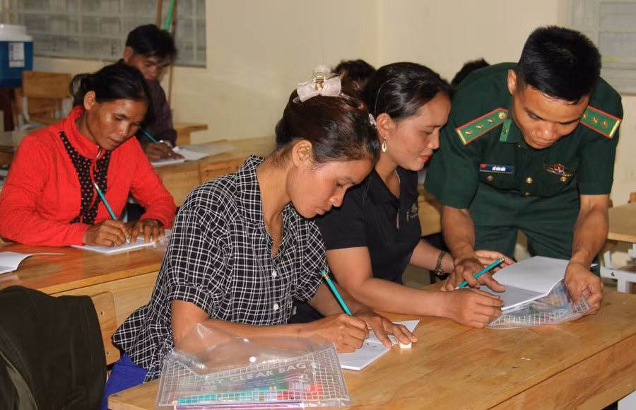 Đại úy Hồ Văn Hữu, Đội trưởng Vận động quần chúng, Đồn Biên phòng Ba Tầng, Ban Chỉ huy Bộ đội Biên phòng tỉnh Quảng Trị hướng dẫn học viên lớp xoá mù chữ. Ảnh NVCC.