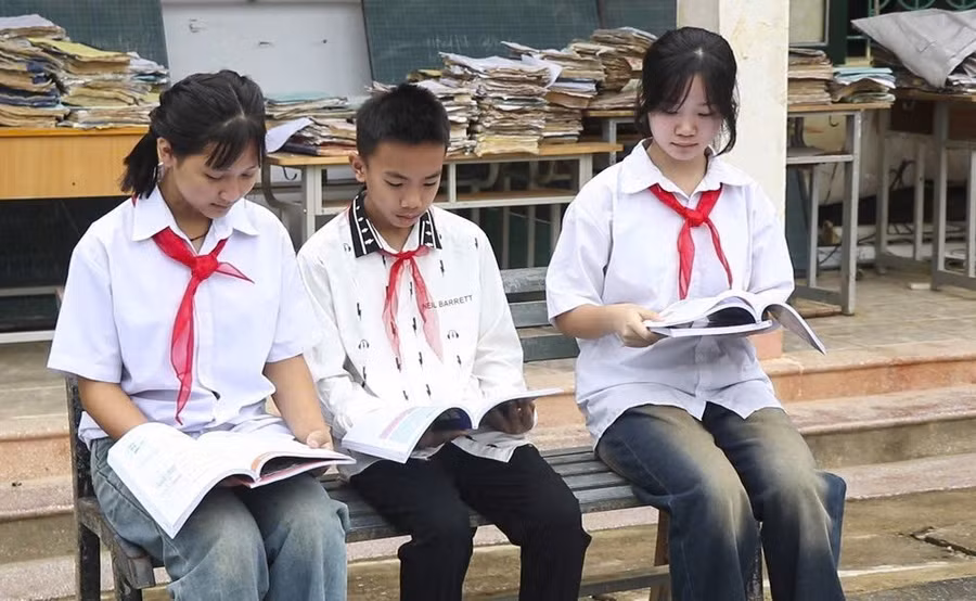 Học sinh Trường Phổ thông Dân tộc bán trú THCS Chiềng Sơ (xã Mường Luân) đọc sách giáo khoa mới. Ảnh: TTXVN.
