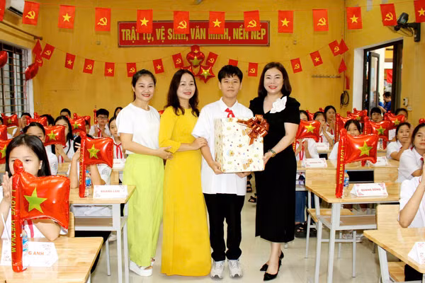 Thầy cô giáo cùng đại diện cha mẹ học sinh trường THCS Nha Trang (Thái Nguyên) tặng quà học sinh lớp 6 tựu trường.