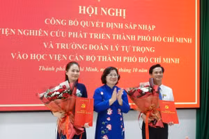 Bà Nguyễn Thị Nhật Hằng (bìa trái) nhận quyết định bổ nhiệm làm Giám đốc Học viện Cán bộ TPHCM. 