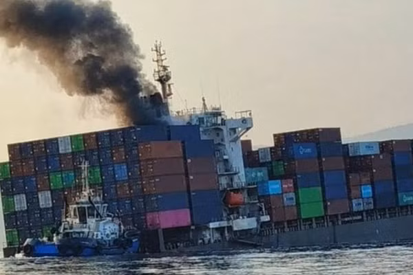 Khói bốc lên từ con tàu container GFS Pride bị cháy đang nghiêng, sau khi va phải thủy lôi ở eo biển Hormuz, ngày 14/10/2026. 