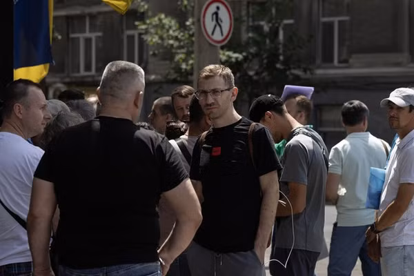 Những người đàn ông Ukraine chờ đợi bên ngoài một trung tâm tuyển quân ở Odessa.