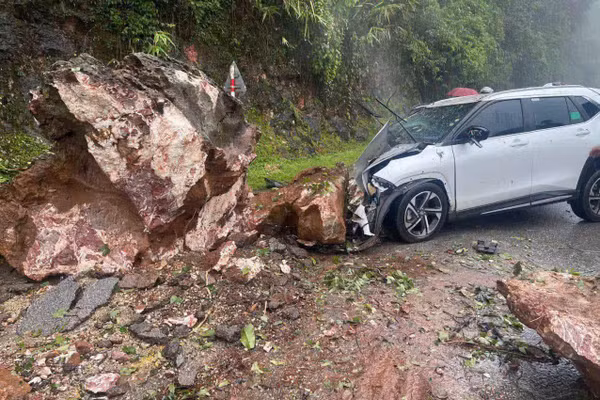 Đầu xe ô tô bị bẹp nát do đá lăn trúng.