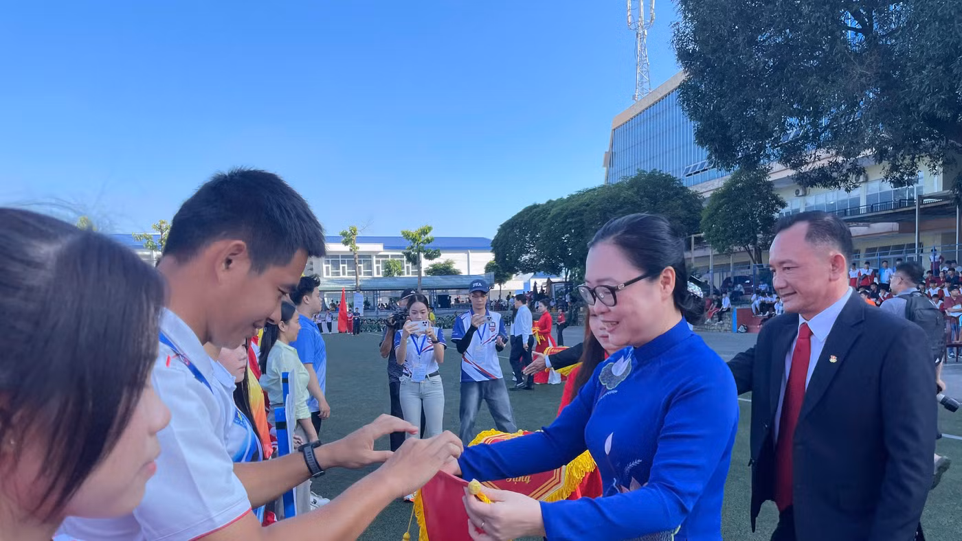 Thứ trưởng Bộ GD&ĐT Nguyễn Thị Quyên Thanh trao cờ lưu niệm cho các đoàn vận động viên. Ảnh: Hà An.