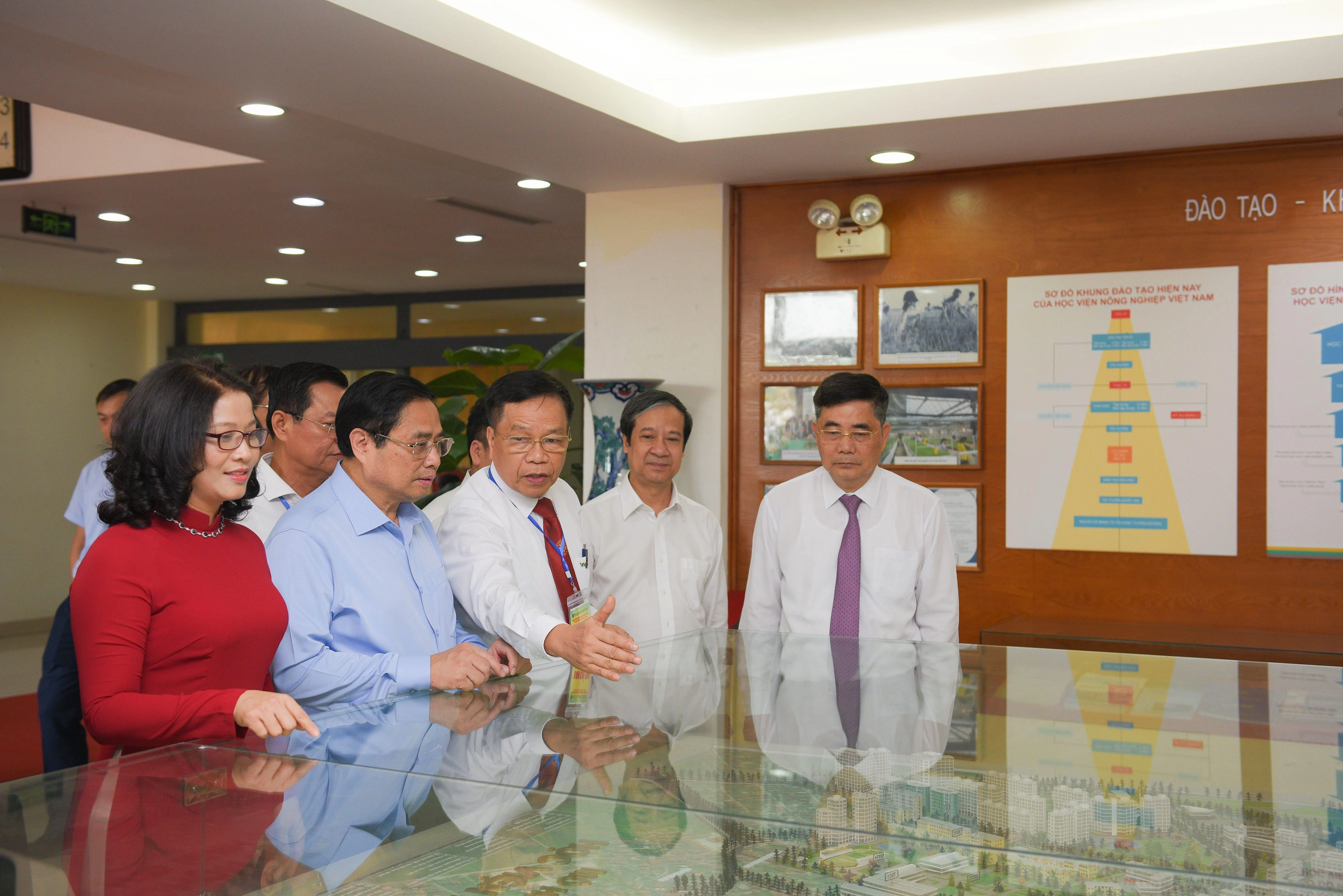 Thủ tướng Phạm Minh Chính (thứ hai từ trái qua phải), Bộ trưởng Bộ GD&amp;ĐT Nguyễn Kim Sơn (thứ hai từ phải qua trái) cùng đại diện các bộ, ngành, cơ quan Trung ương thăm mô hình của Học viện Nông nghiệp Việt Nam