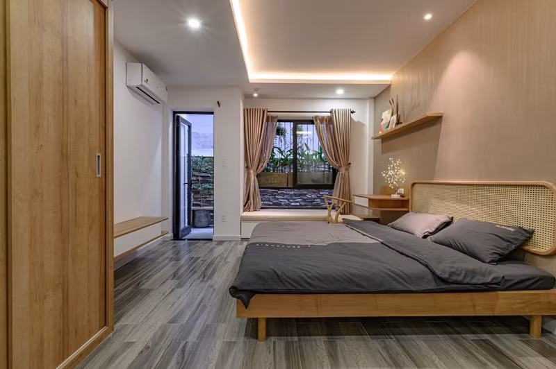 Phòng ngủ kết nối với cây xanh bên ngoài.